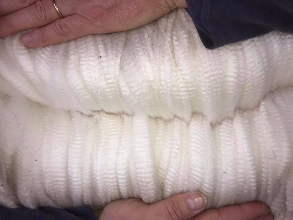 Close-up of hands on textured white fabric