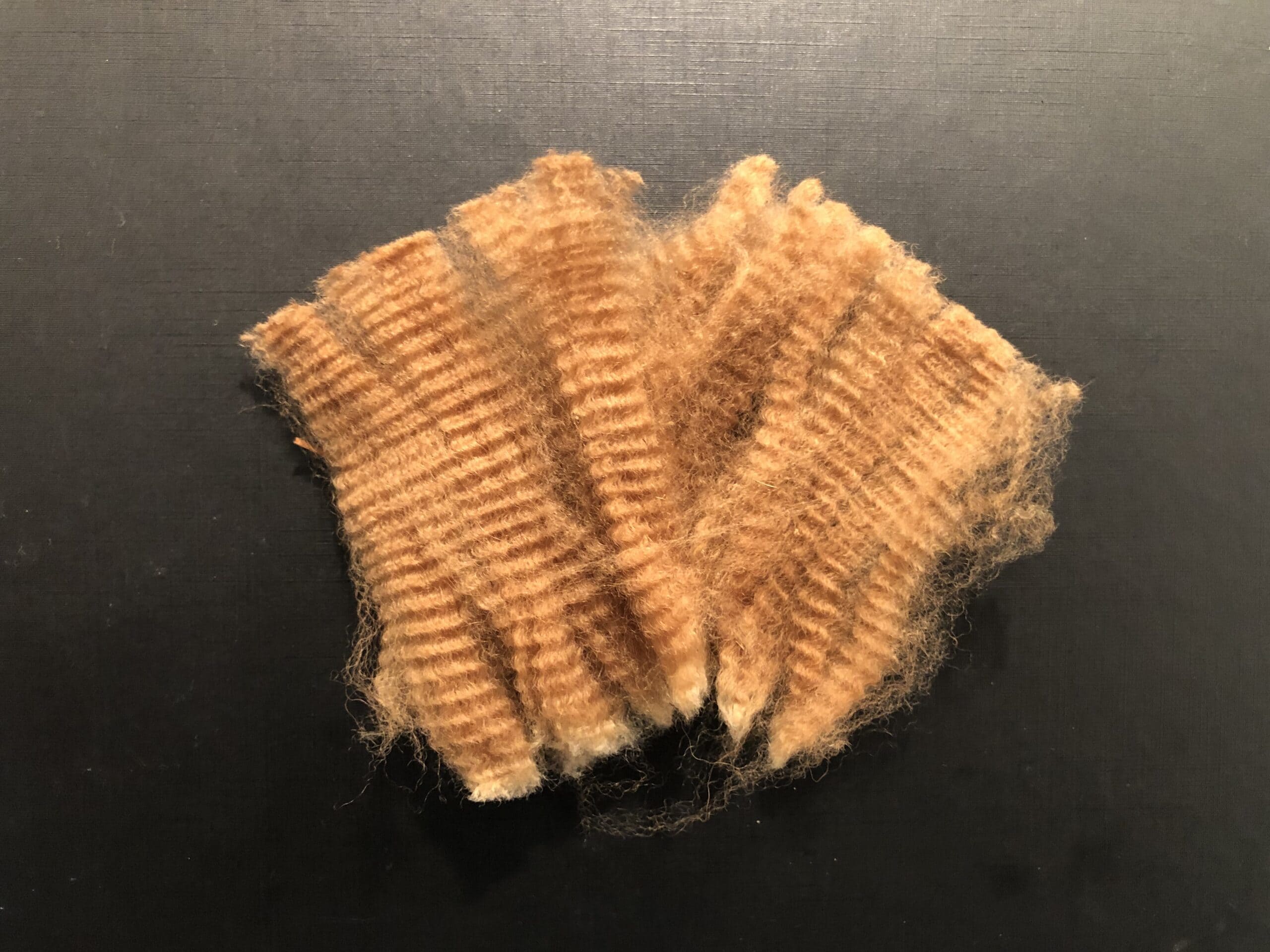 Worn brown fabric scrap on dark background