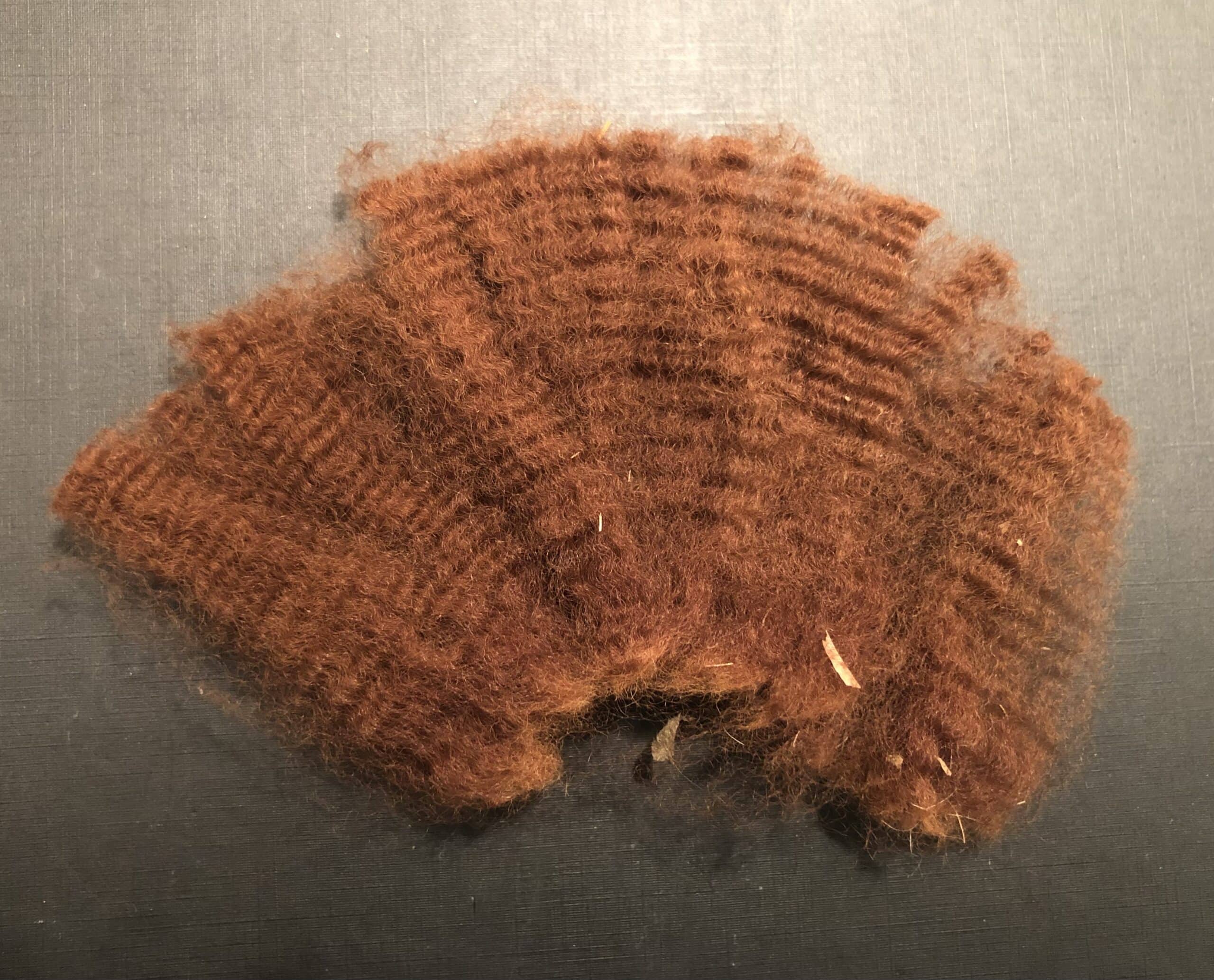 Fluffy, rust-coloured wool fibres on texture
